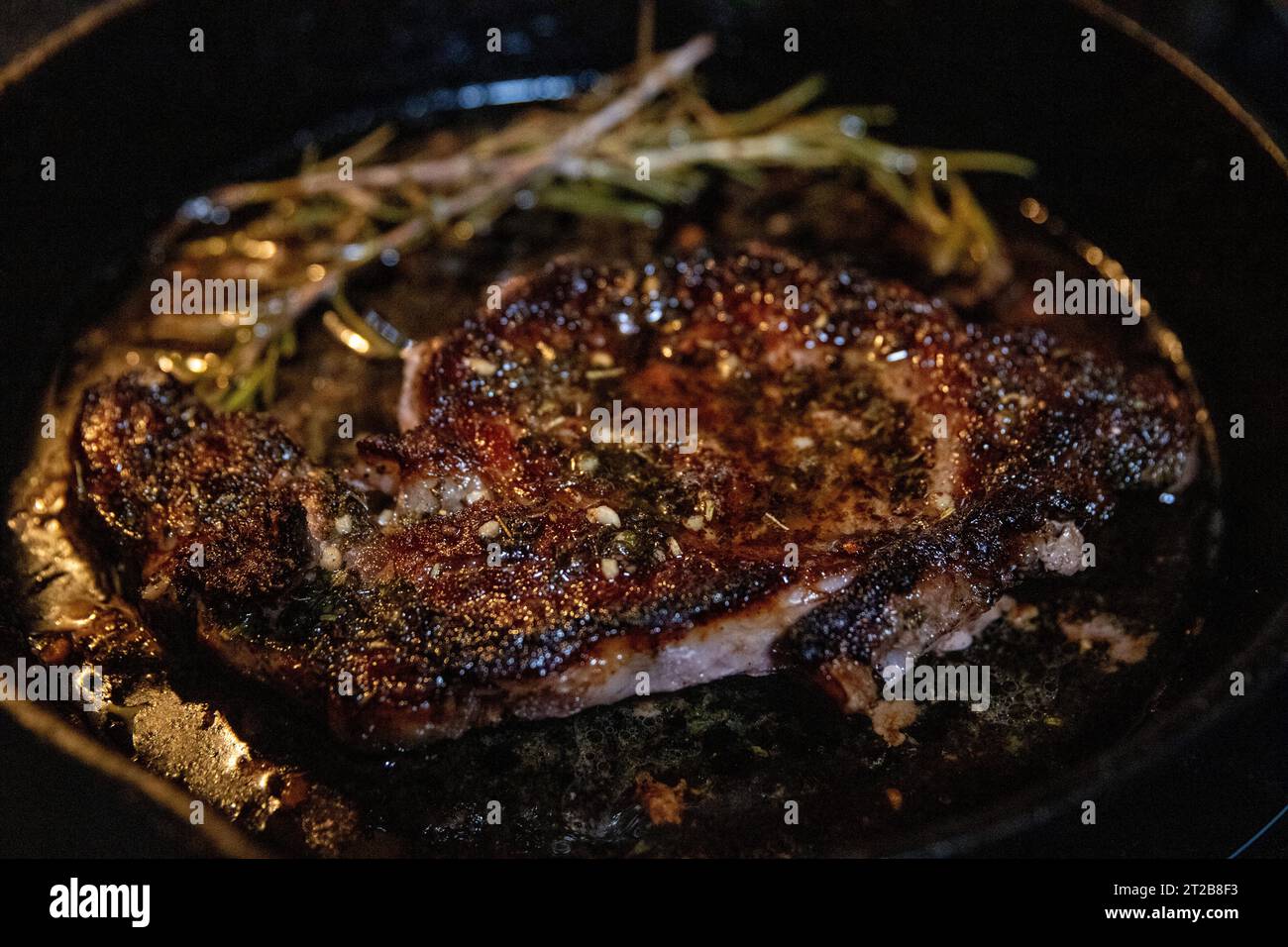 Cast iron rib eye with rosemary and butter Stock Photo Alamy