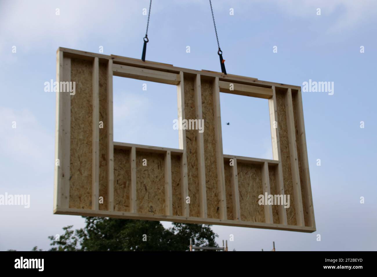 Wall with window of a prefabricated house is built with a crane Stock Photo