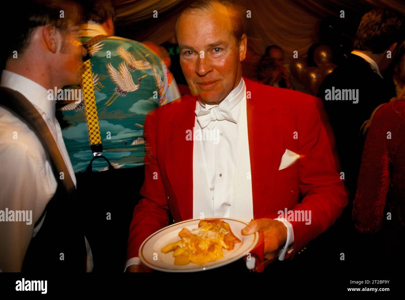 Hunt breakfast, Master of the Foxhounds, MFH wearing traditional Hunting Pink he has been queuing up and is now served his breakfast. Everyone has been up all night.  Tysoe, Warwickshire, England April 1982. 1980s UK HOMER SYKES. Stock Photo