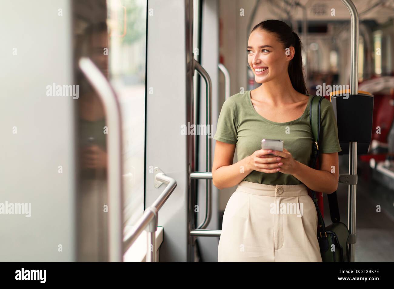 Passenger woman browsing on phone in tram indoor Stock Photo