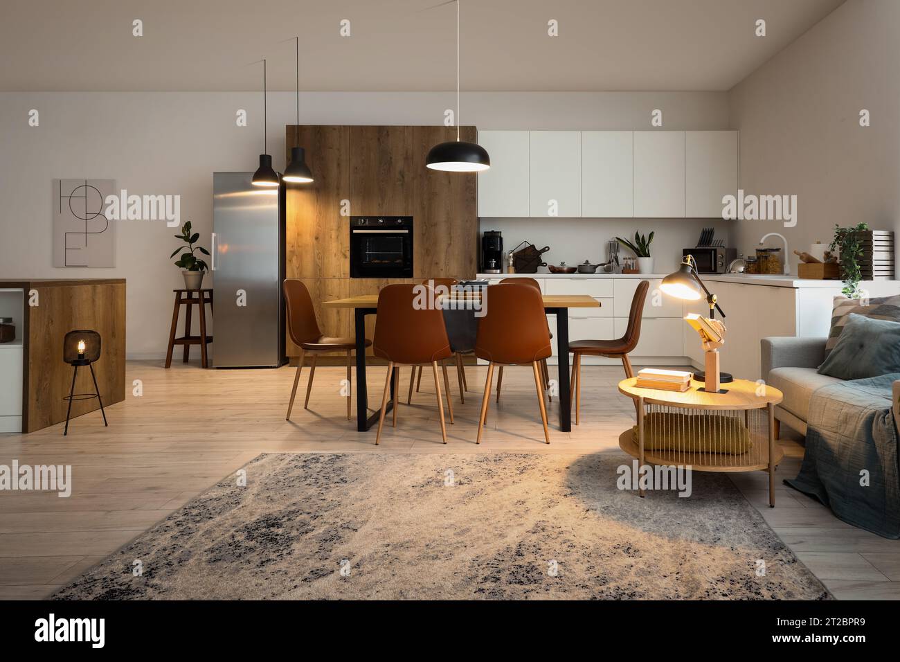 Interior of modern open plan kitchen with dining table and glowing ...