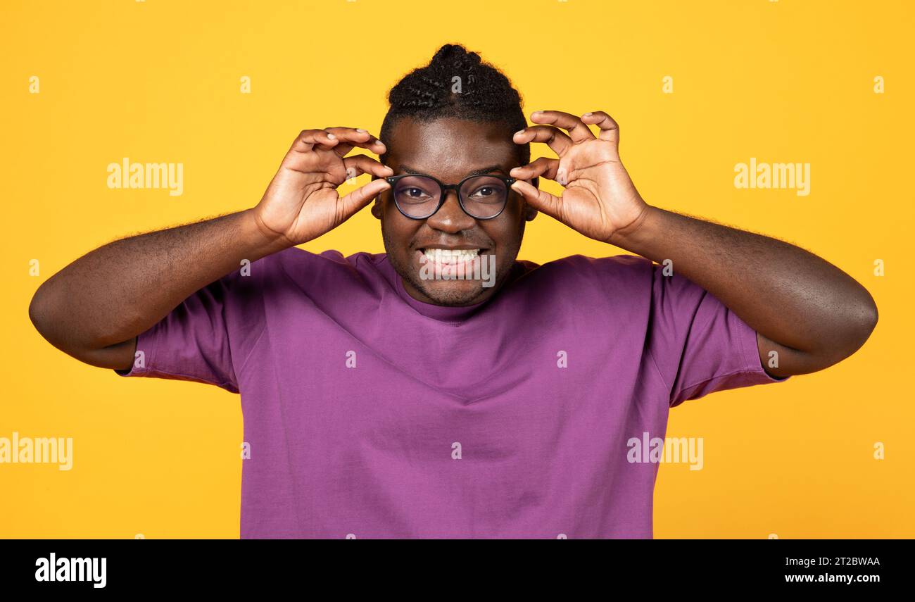 Black Guy Looking At Camera Through Glasses Over Yellow Background ...