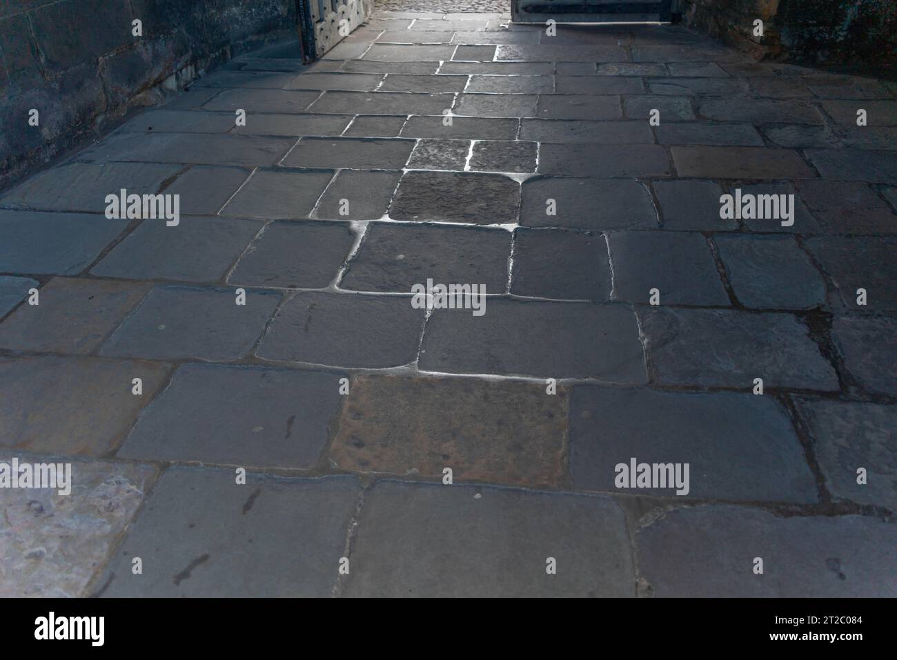 Slabs, walkway, walked smooth, centuries of use, thoroughfare, path, footfall, polished, sandstone, sedimentary rock, slippery, shadows, passage time. Stock Photo