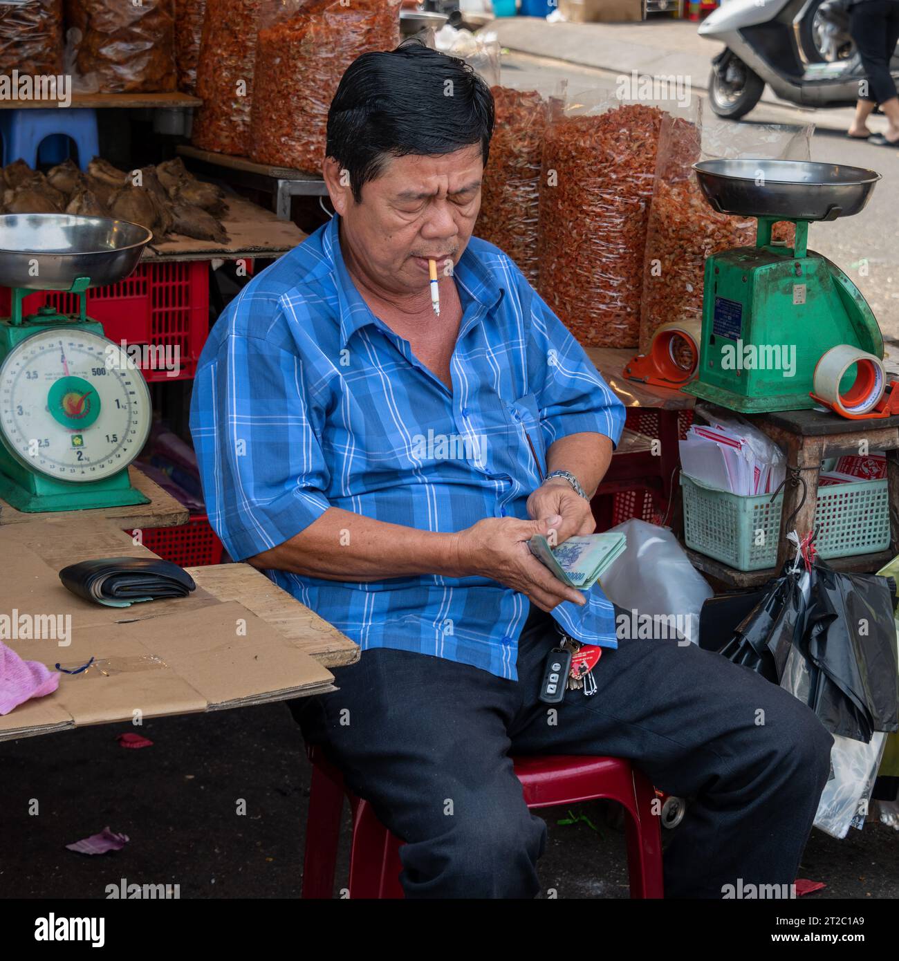 Market Trader Counting Money, Saigon, Vietnam Stock Photo