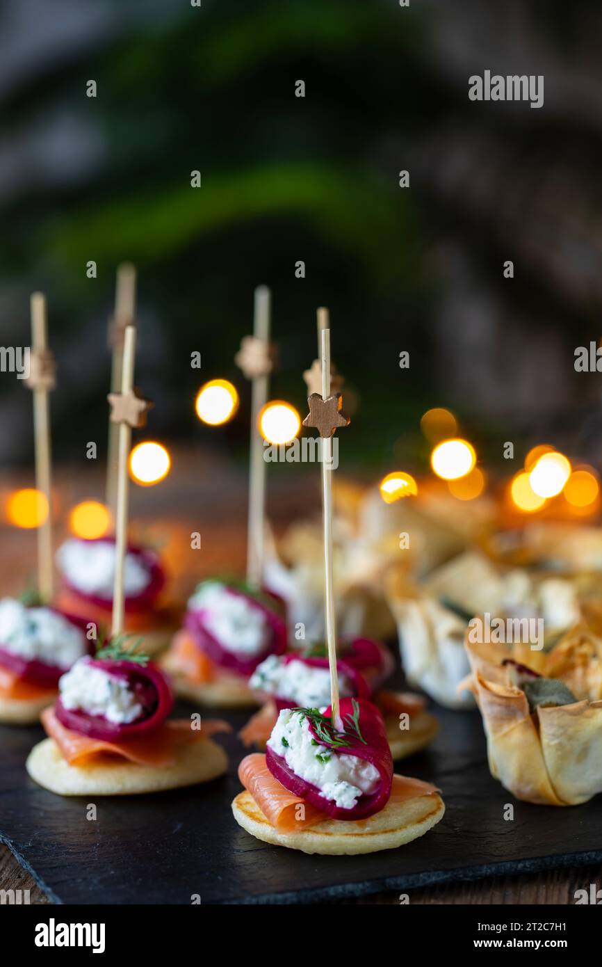 Christmas canapes with blinis with salmon, beetroot and goat cheese and filo pastry cups Stock Photo