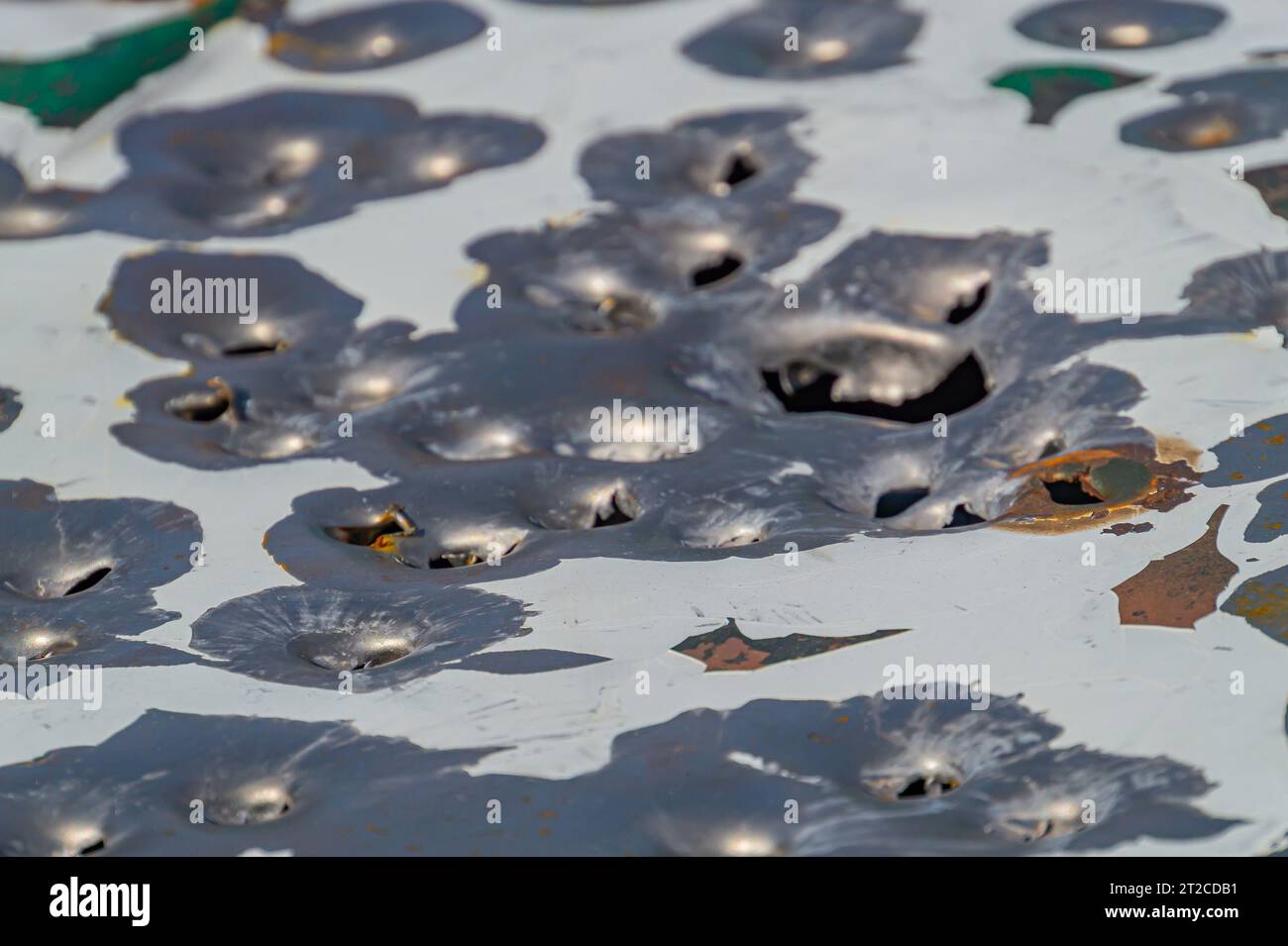 bullet holes in the metal. multiple bullet marks on the car body. peeling green. bullet holes, texture, metal, shooting, shooting on the street, shot, Stock Photo