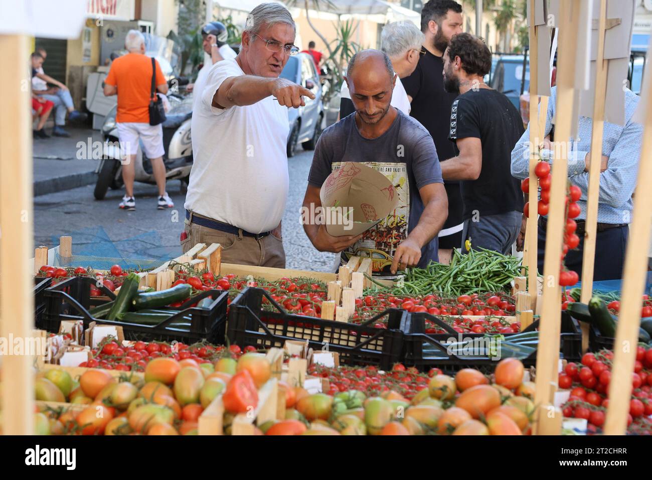 A market vendor sells runner beans to a customer in Ballarò market, Palermo, Sicily, Italy Stock Photo