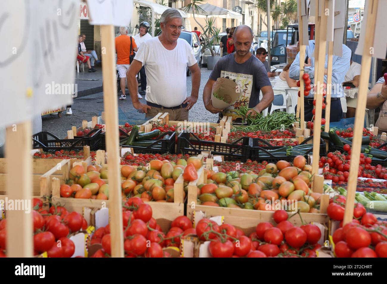 A market vendor sells vegetables to a customer in Ballarò market, Palermo, Sicily, Italy Stock Photo