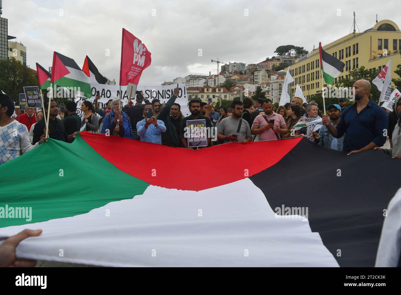 Lisbon, Portugal. 18th Oct, 2023. Activists are seen holding a large Palestinian flag and anti-war placards during a demonstration. The rally calling for a ceasefire and an end to the Israeli-Palestinian conflict was organized by the Portuguese Council for Peace and Cooperation and the Movement for the Rights of the Palestinian People. Credit: SOPA Images Limited/Alamy Live News Stock Photo