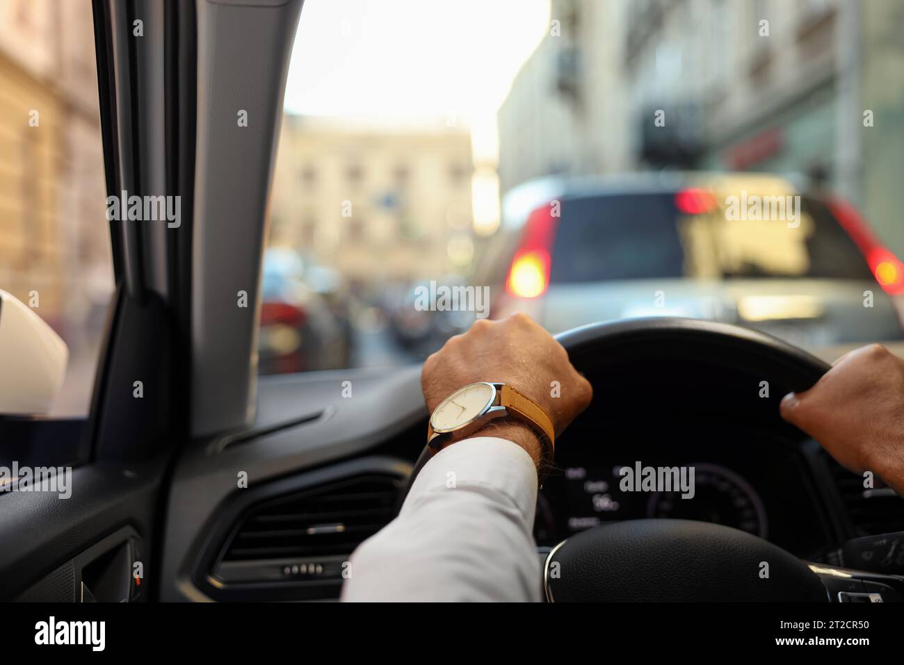 Stuck in traffic jam. Driver holding hands on steering wheel in car