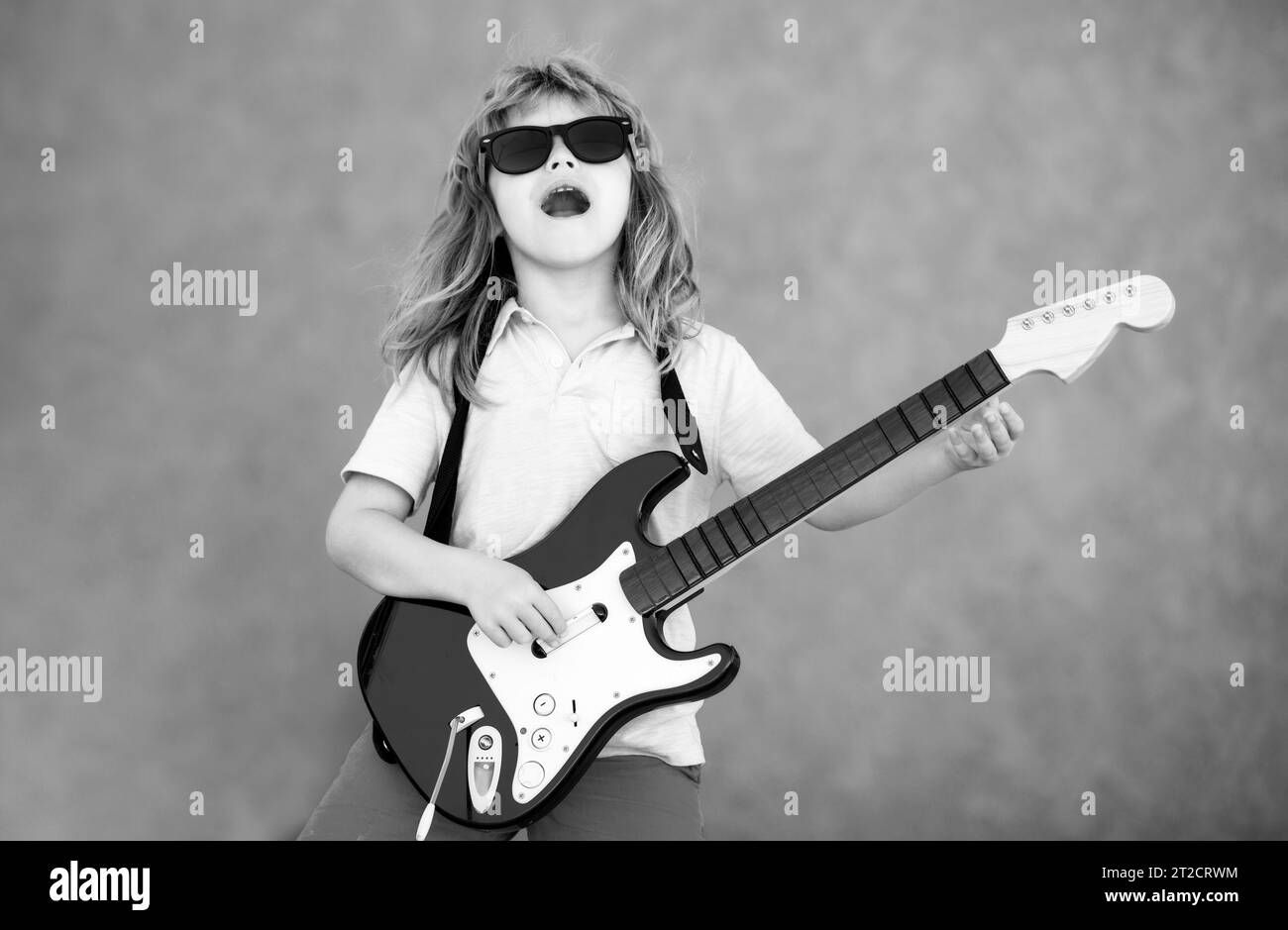 Rock and roll, little kid rock star. Little boy playing guitar outdoor