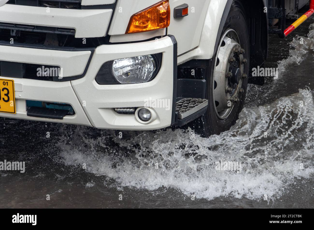 The detailed look at wheel of truck driving through a flooding street the rain Stock Photo