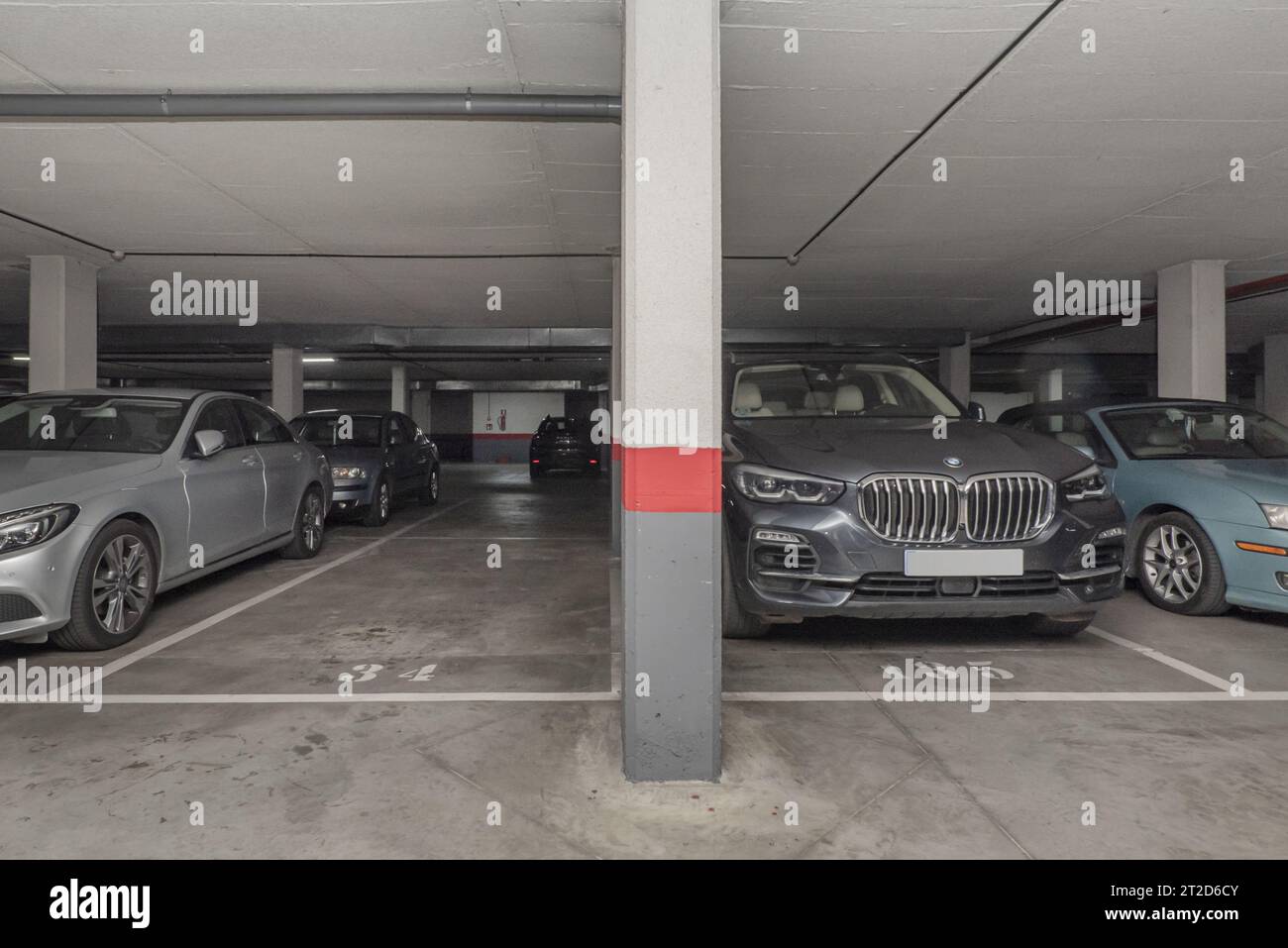 A garage with parked vehicles and some free spaces Stock Photo