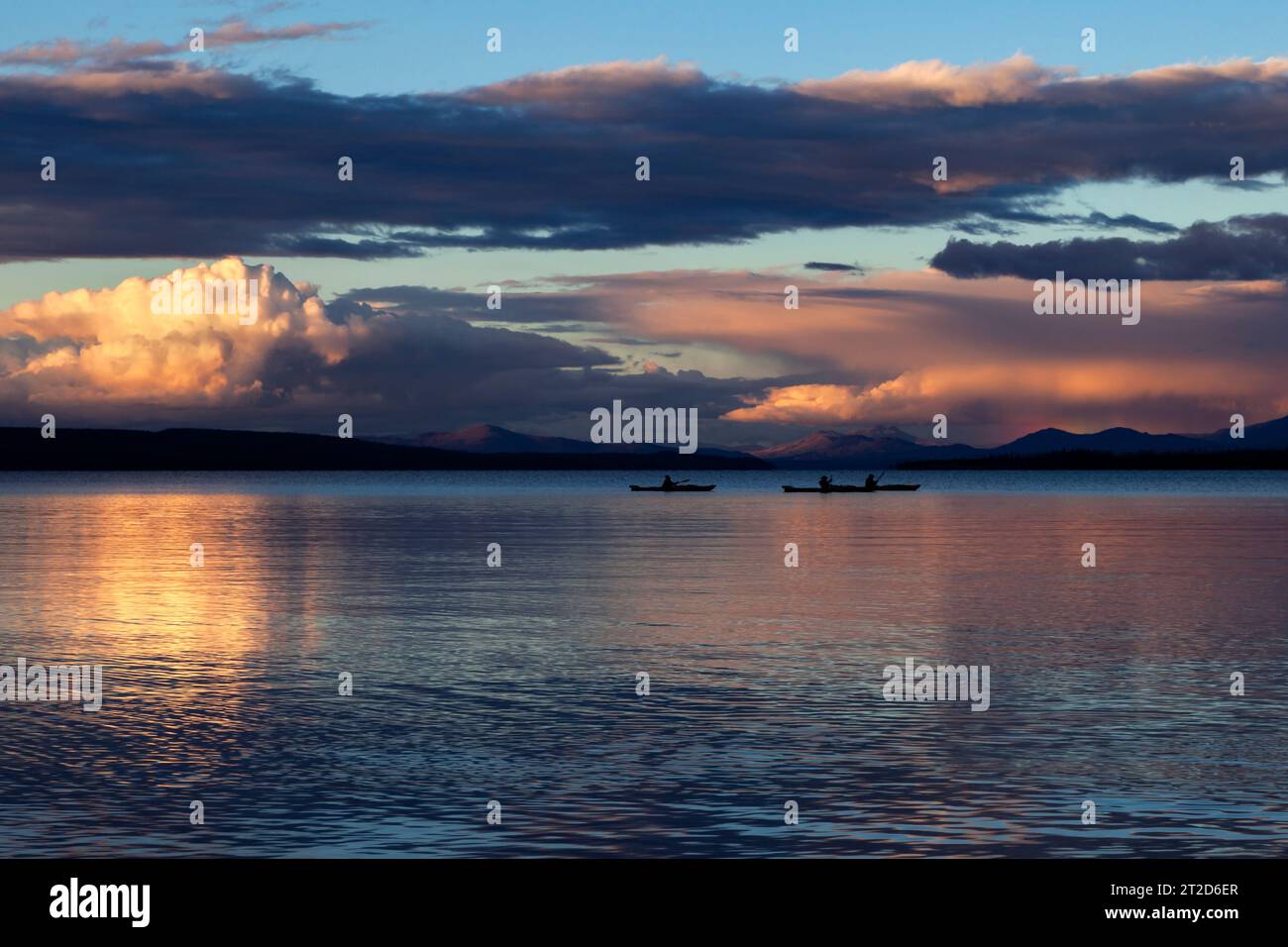 Kayakers end the day on Lake Yellowstone near Grant Village as the cumulous clouds of thunderstorms sit on the horizon in Yellowstone National Park. Stock Photo