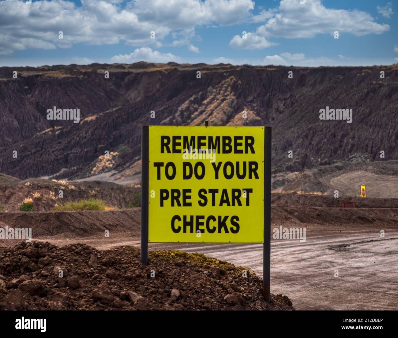 open pit diamond mine, yellow safety check sign to remind workers basic