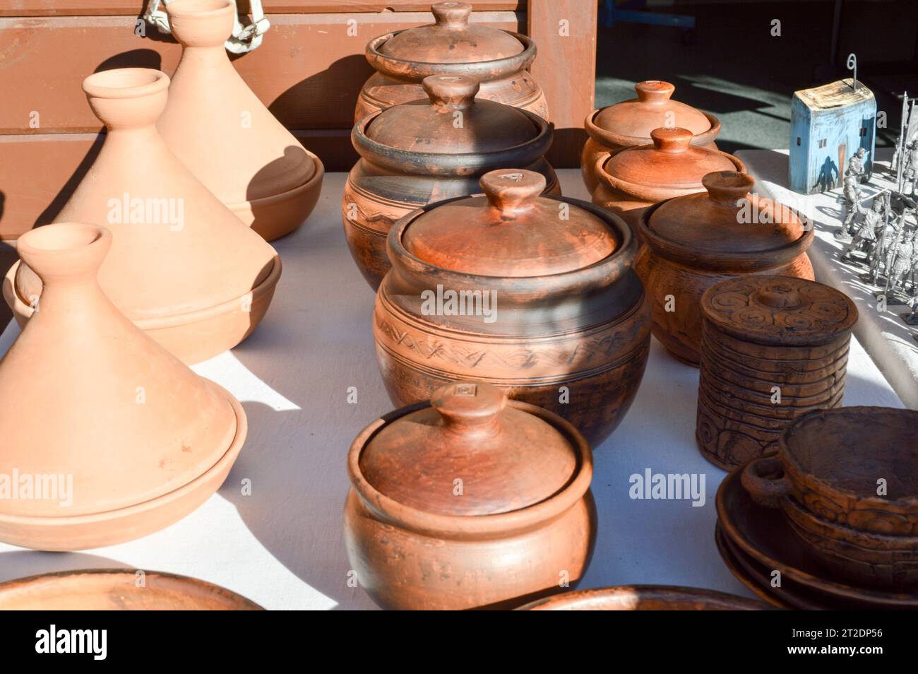 Natural traditional clay pottery beautiful old kitchen appliances, dishes, jugs, vases, pots, mugs. The background. Stock Photo