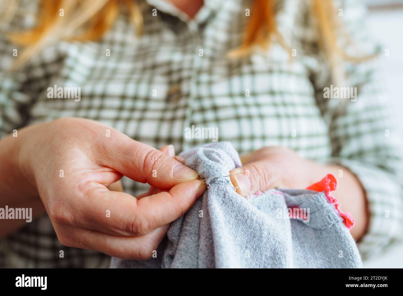 Woman sewing up hole in clothes, handmade Stock Photo Alamy