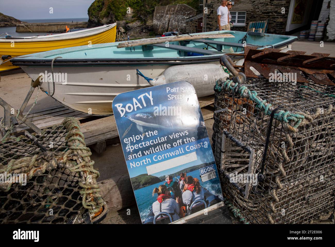 Port Isaac Cornwall boat hire and boat trips being marketed, harbour side with lobster pots,Cornwall,England,UK Stock Photo