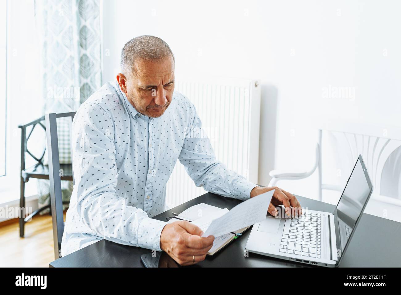 middle-aged man writes notes in notebook Stock Photo