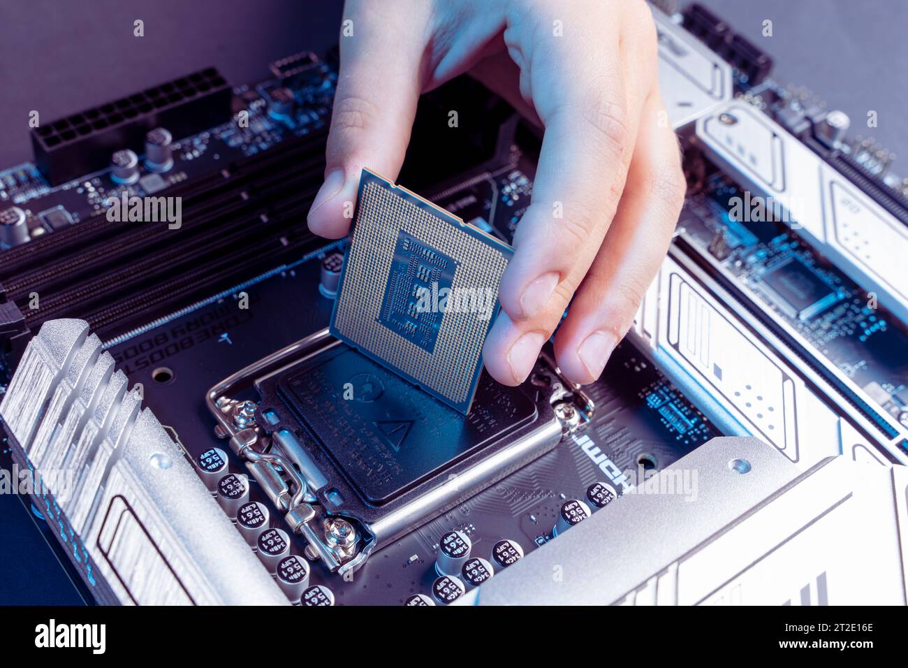 installing the processor into the motherboard socket. modern powerful and fast motherboard with slots for RAM and CPU. the concept of PC hardware. Stock Photo
