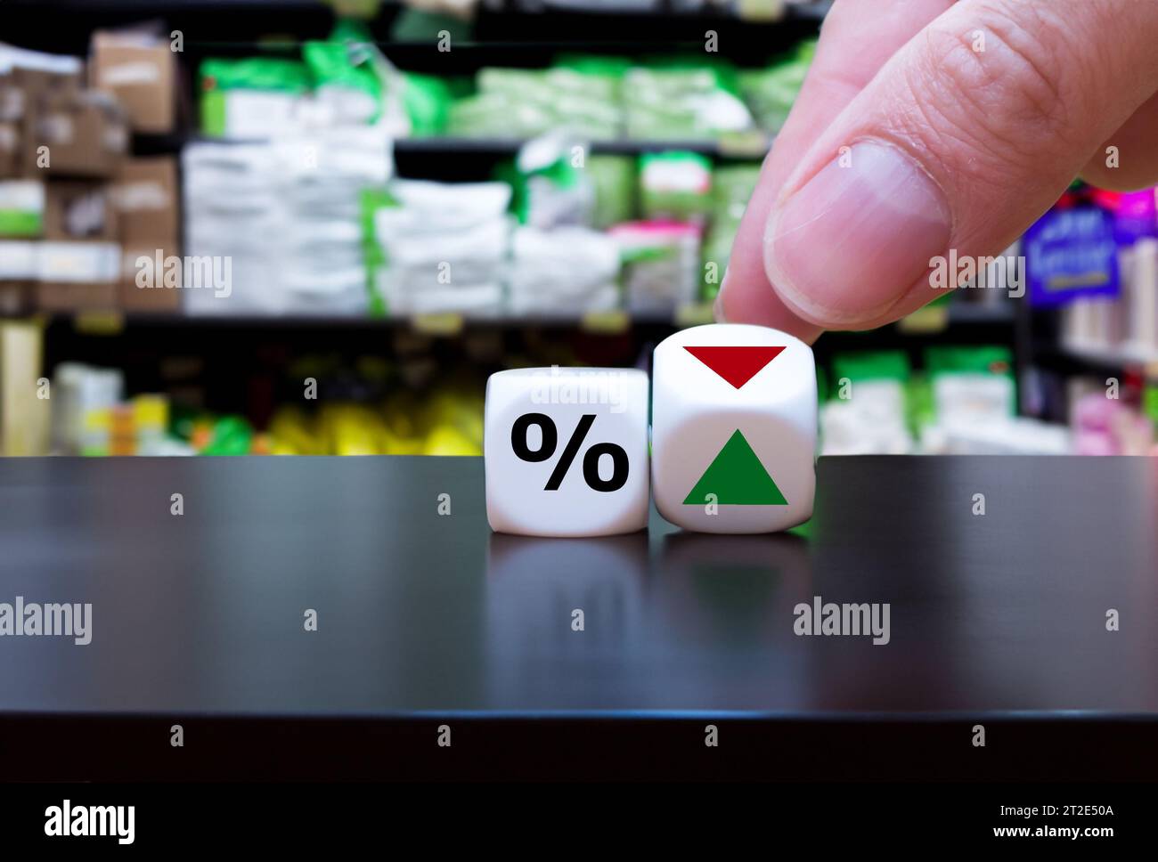 Hand turns dice and changes the orientation of an arrow next to a percentage symbol. Stock Photo