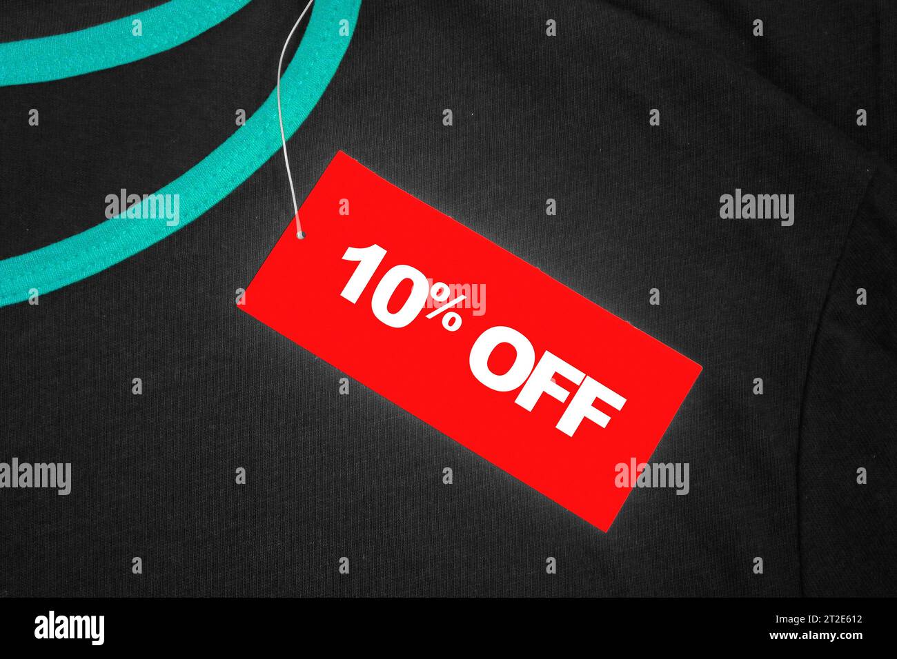 Red tag on a grey and green t-shirt with '10% off' written in white. Stock Photo
