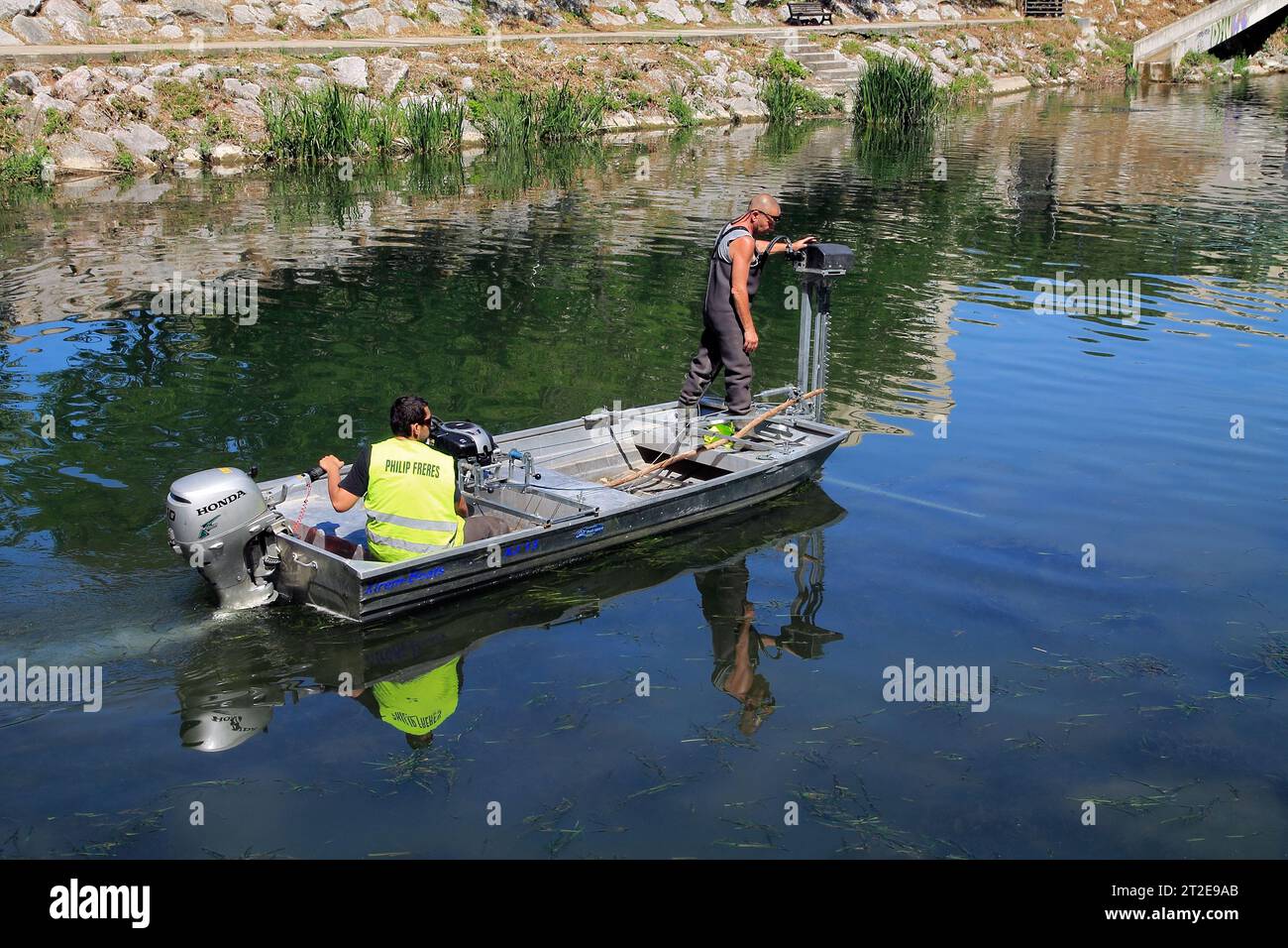 Removing algae with a machine in the Lez River. Philip Brothers Company. Montpellier, Occitanie, France Stock Photo