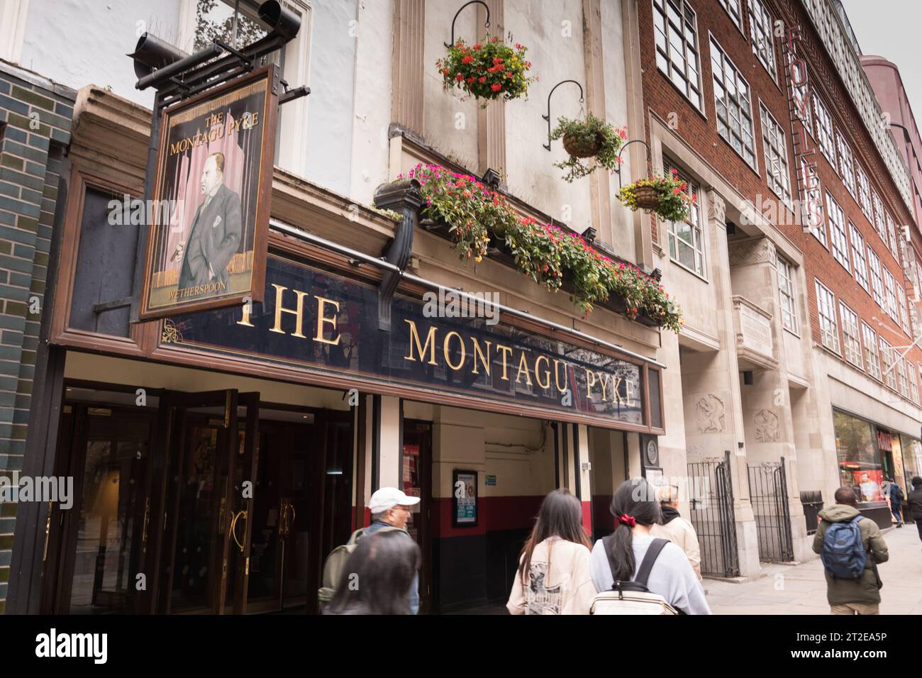 Tourists walking past the Montague Pyke public house, a pub belonging to Wetherspoons chain, on Charing Cross Road, Soho, London, WC2, England, U.K. Stock Photo