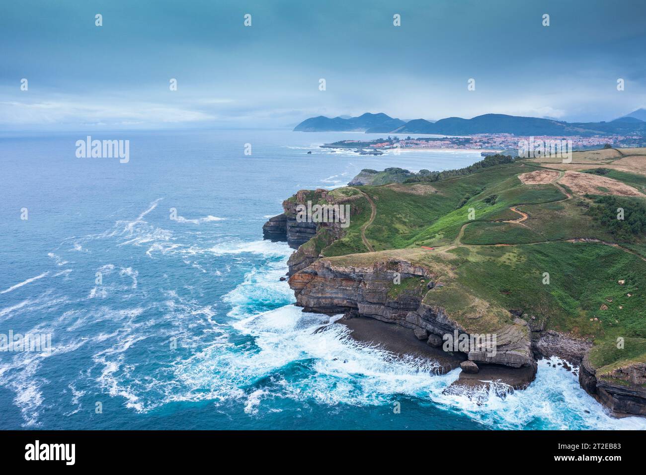 Aerial view of a coastal landscape with rocky cliffs and green meadows. Cantabria, Spain. Stock Photo