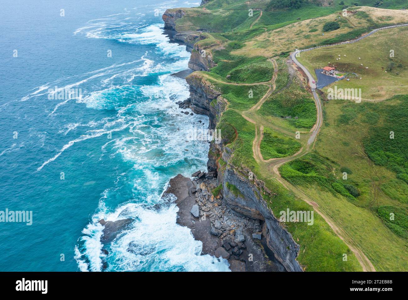 Aerial view of a coastal landscape with rocky cliffs and green meadows. Cantabria, Spain. Stock Photo
