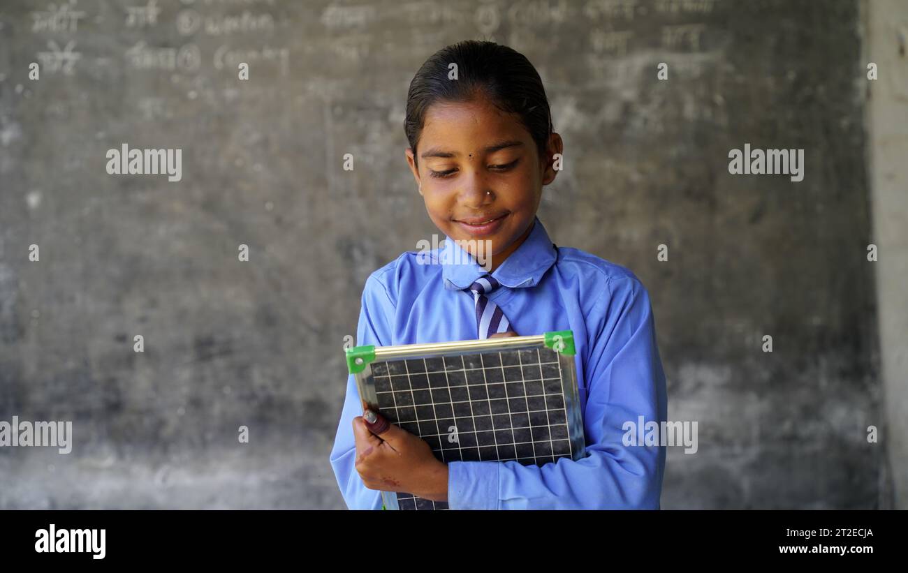 Portrait of happy indian school child sitting at desk in classroom, school kids with pens and notebooks writing test Elementary school, Education conc Stock Photo