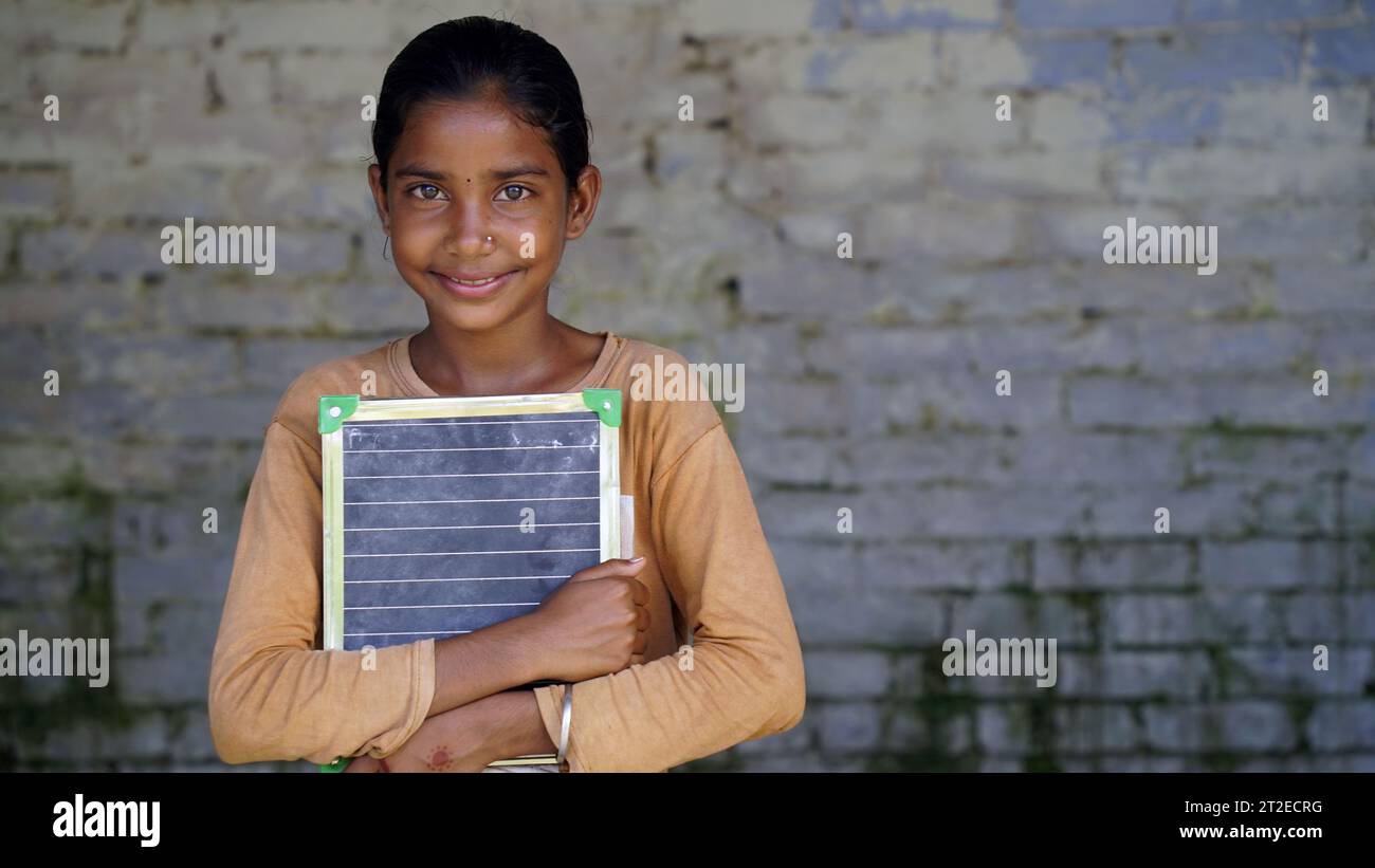 Portrait of happy cute little indian girl in school uniform holding ...