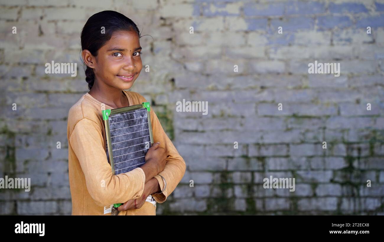 Portrait of happy cute little indian girl in school uniform holding ...
