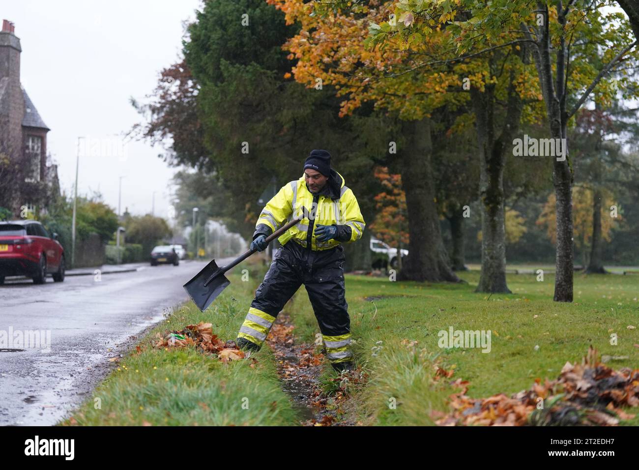 A workman clears a drainage ditch in the village of Edzell, Scotland, ahead of Storm Babet. The UK is bracing for heavy wind and rain from Storm Babet, the second named storm of the season. A rare red weather warning stating there is a 'risk to life' has been issued for parts of Scotland as the storm is expected to batter the UK on Thursday. Picture date: Thursday October 19, 2023. Stock Photo