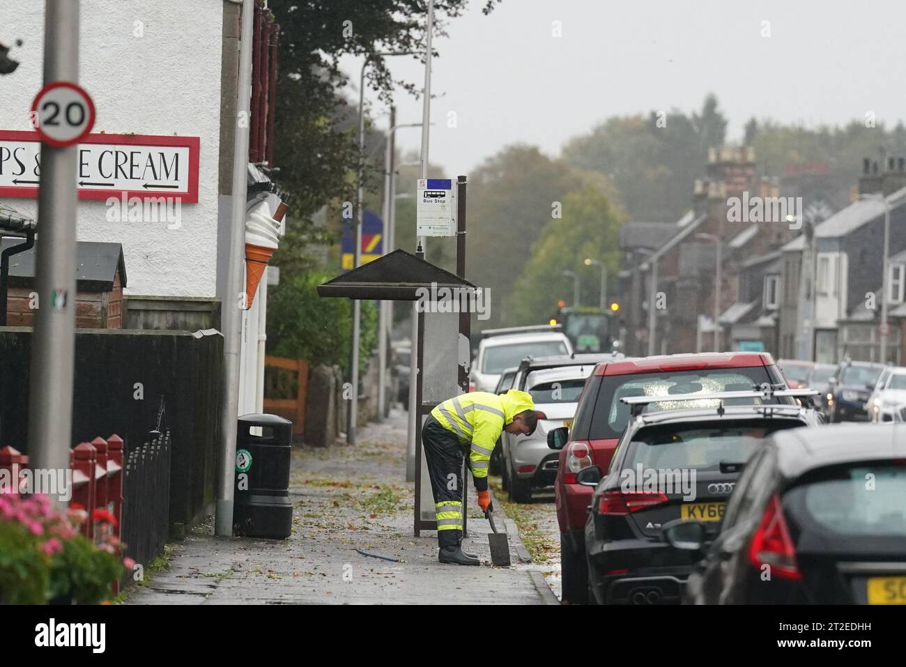 A workman clears the drains in the village of Edzell, Scotland, ahead of Storm Babet. The UK is bracing for heavy wind and rain from Storm Babet, the second named storm of the season. A rare red weather warning stating there is a 'risk to life' has been issued for parts of Scotland as the storm is expected to batter the UK on Thursday. Picture date: Thursday October 19, 2023. Stock Photo