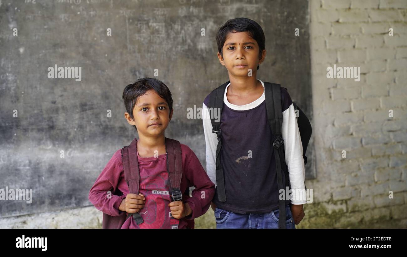 Smiling Indian Rural school boy with backpack looking at camera. Cheerful kid wearing school uniform with a big smile. Elementary and primary school e Stock Photo