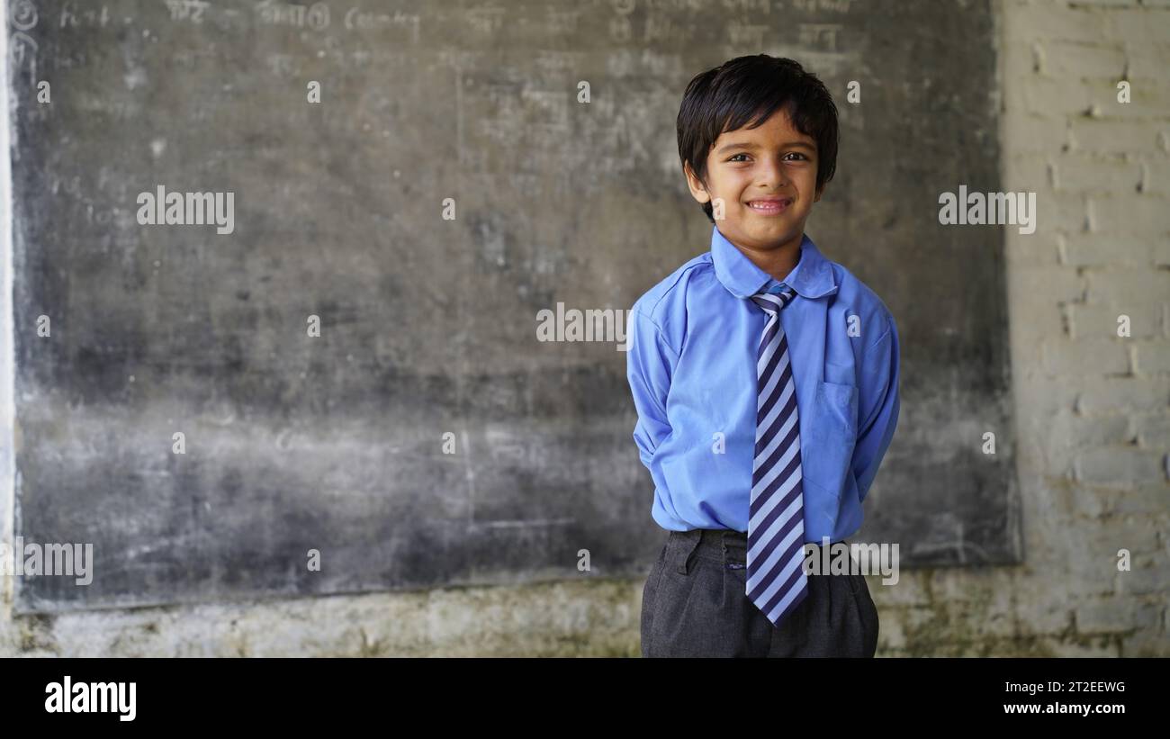 Portrait of happy indian school child sitting at desk in classroom, school kids with pens and notebooks writing test Elementary school, Education conc Stock Photo