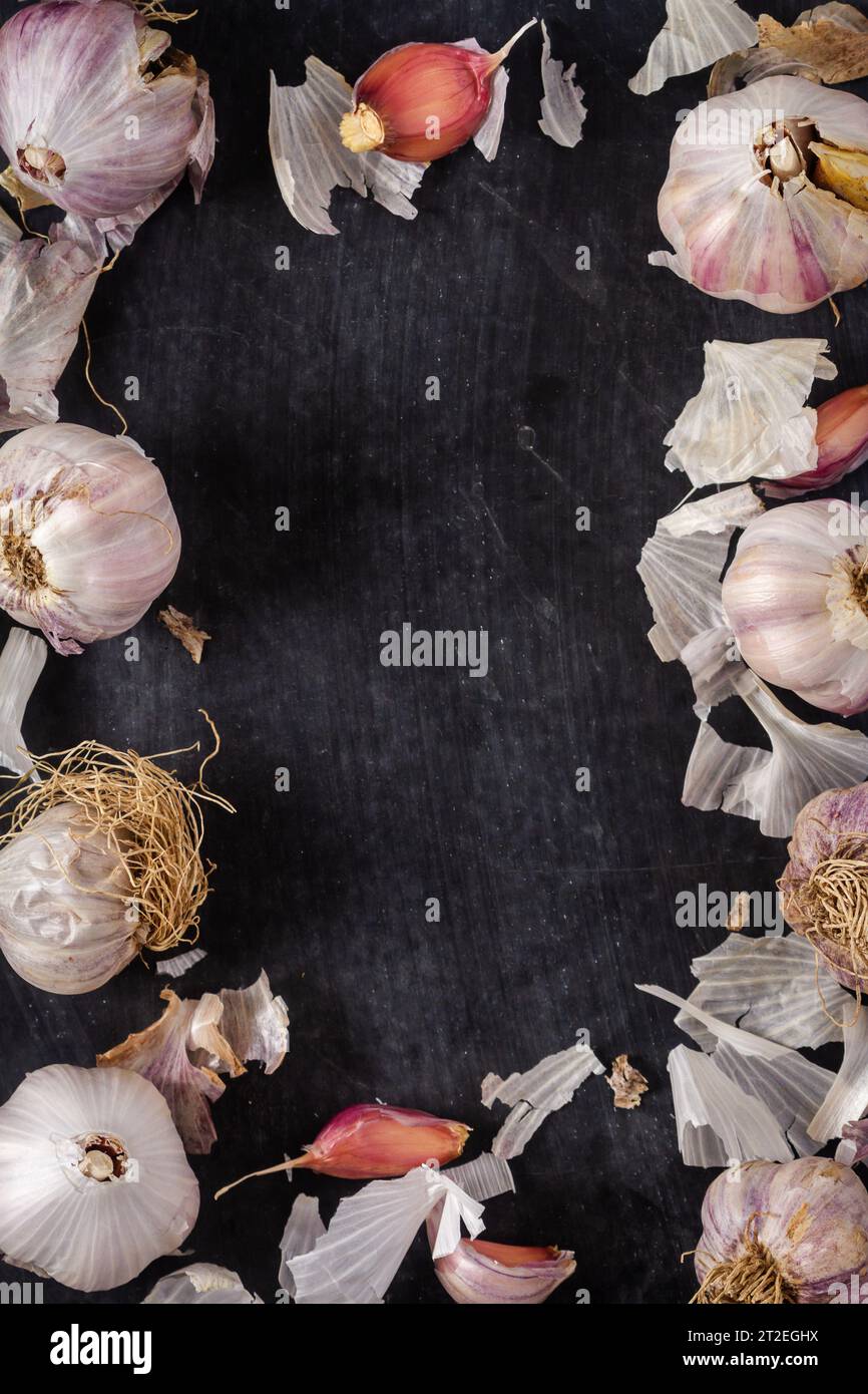 Fresh garlic bulbs and cloves grouped on black background. Flat lay ...