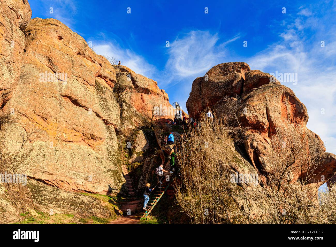 Group of active seniors hiking and climbing,the steps leading to impressive rock formations,  Belogradchik Fortress, Kaleto, Bulgaria Stock Photo