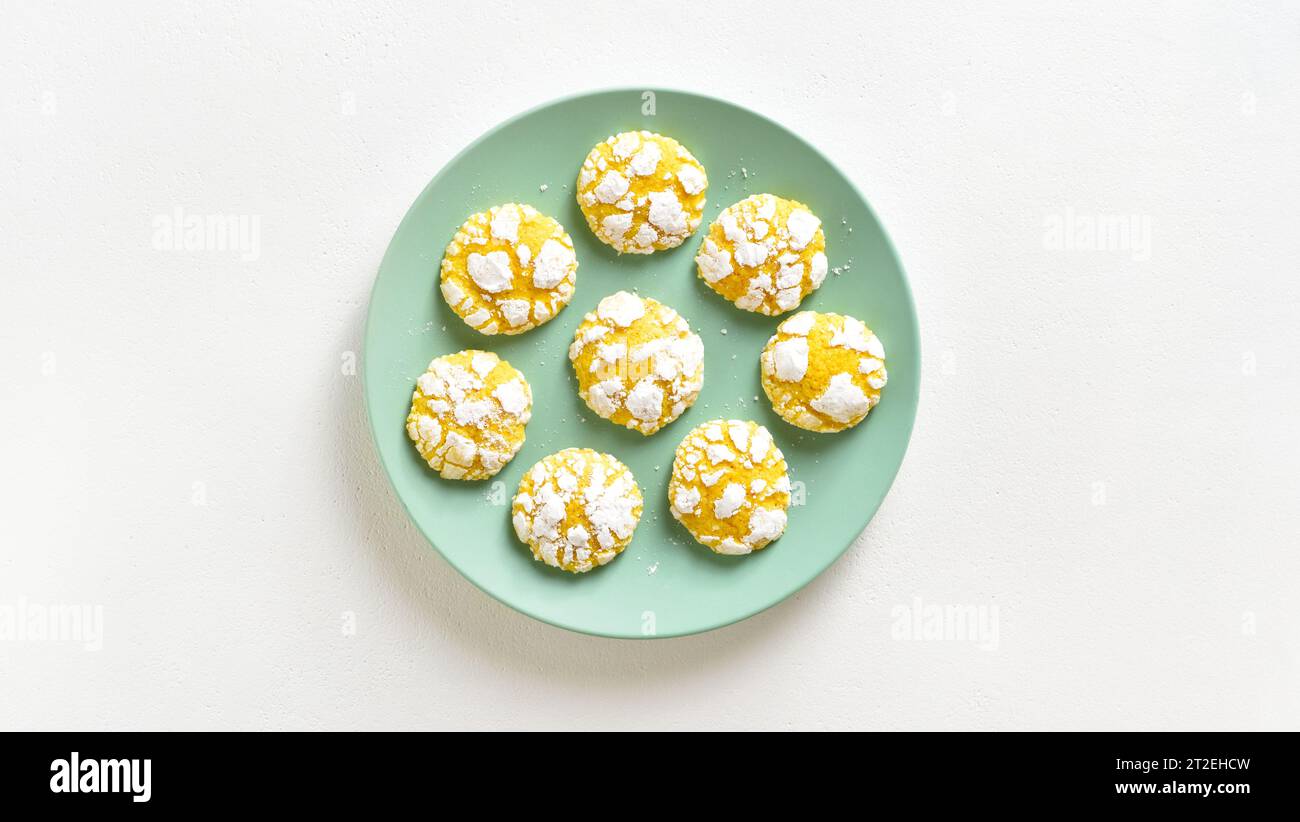 Homemade lemon crinkle cookies on plate over white background with copy space. Top view, flat lay Stock Photo