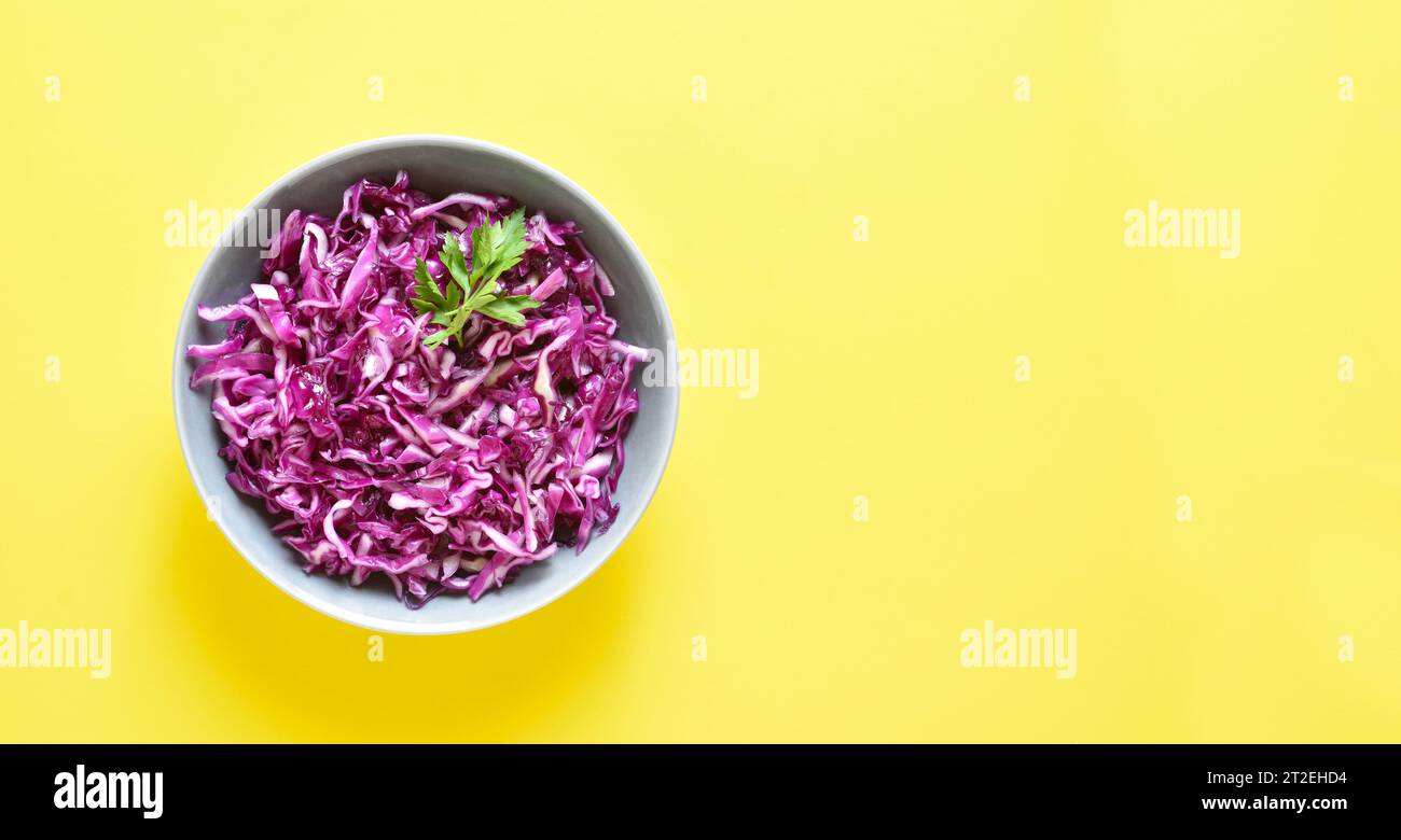 Red cabbage in bowl over yellow background with copy space. Top view, flat lay Stock Photo