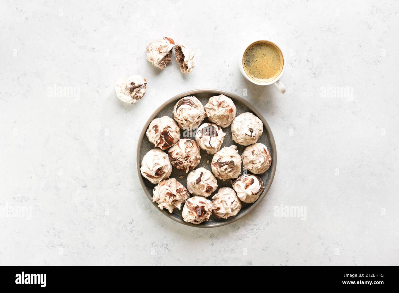 Chocolate meringue cookies and cup of coffee over light background with free space. Top view, flat lay Stock Photo