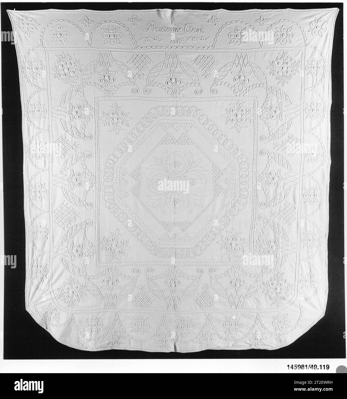 Embroidered whitework coverlet Prudence Clark American 1817 Three panels of a linen/cotton ribbed fabric are seamed together to form the base of this whitework coverlet. The piece is embroidered in loops with heavy white cotton thread. The central medallion is set within an octagon of interlocking rings, which in turn is surrounded by two abstract floral borders. Stock Photo