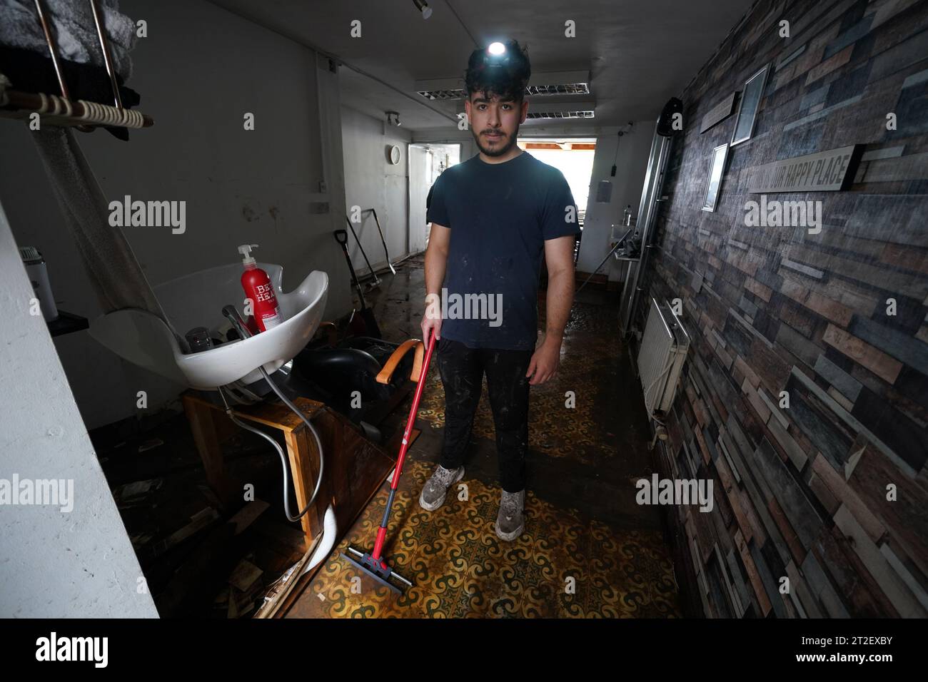 Firat Freddie Uygun inside his barber shop Fresh 'N' Freddie on Main street in Midleton, Co Cork, damaged by flooding after Storm Babet, the second named storm of the season, swept in. Picture date: Thursday October 19, 2023. Stock Photo