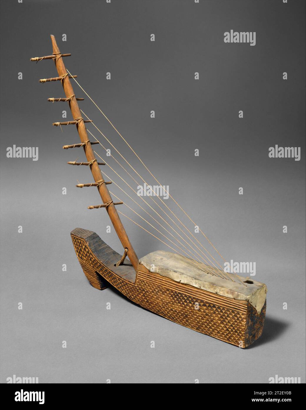 Ngombi (arched Harp) Fang/Kele people 19th century Ngombi (ombi) with fiber strings.Unlike the triangular European harp, the arched harp consists of two elements, a soundbox with a curved neck rising from it. Strings made of gut or plant fiber rise diagonally from the soundtable. Stock Photo