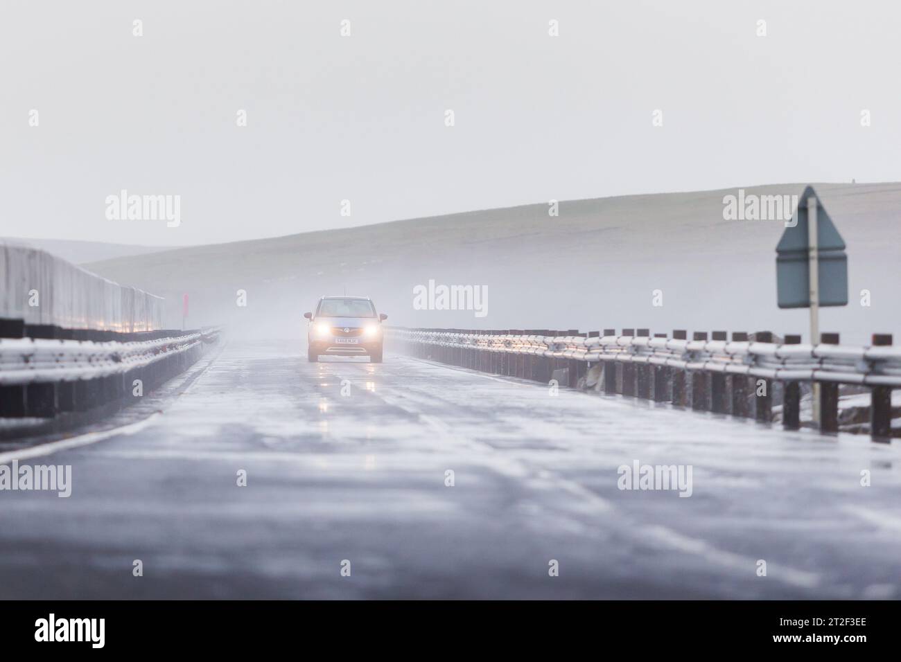 Orkney, UK. 19th Oct, 2023. UK WEATHER: Storm Babet hits Orkney with gale force winds as the Met Office put out a yellow weather warning for the north east of Scotland. A motorist braves the high winds and crashing waves as he crosses one of the Churchill Barriers on the islands. Credit: Peter Lopeman/Alamy Live News Stock Photo