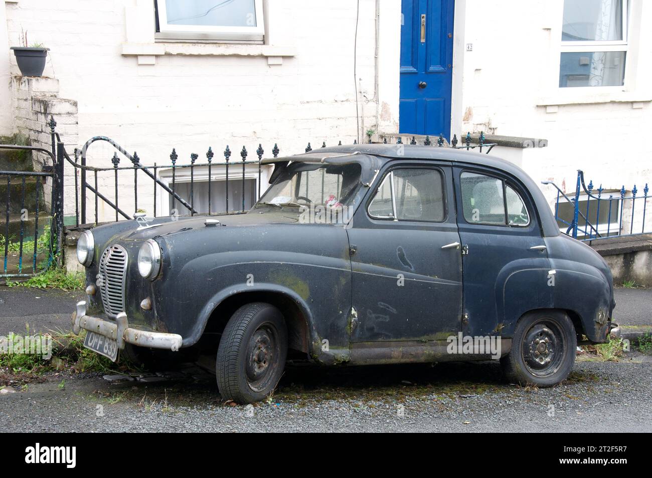 Dilapidated old black 1955 A30 Austin seven, four door saloon, classic motor car. Left neglected in a Bristol backstreet. England, United Kingdom, UK. Stock Photo
