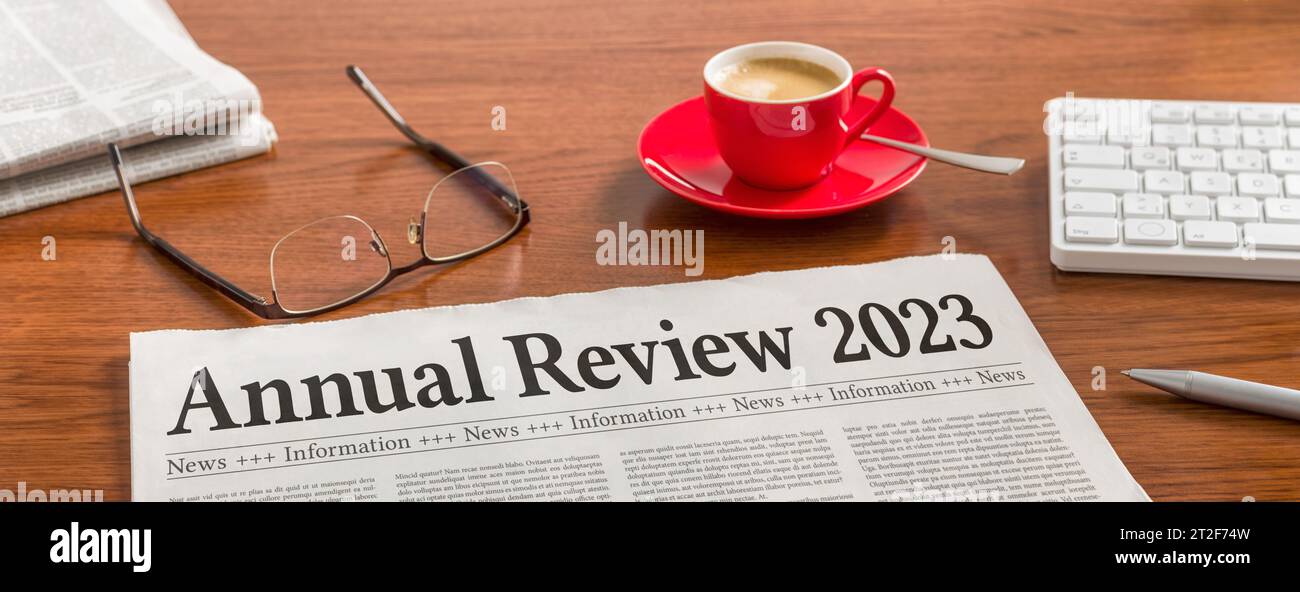 A newspaper on a wooden desk - Annual review 2023 Stock Photo