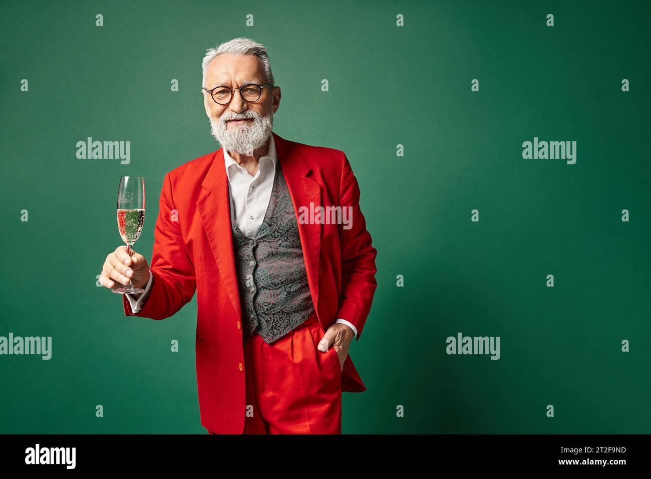good looking white bearded Santa posing with champagne and one hand in pocket, winter concept Stock Photo