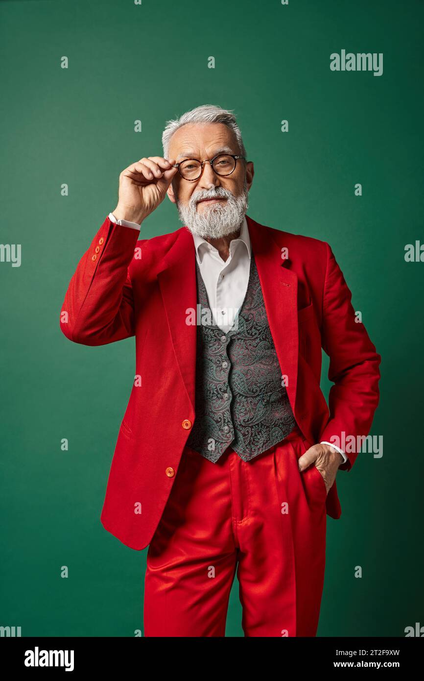 elegant classy Santa with white beard and glasses posing with one hand in pocket, winter concept Stock Photo
